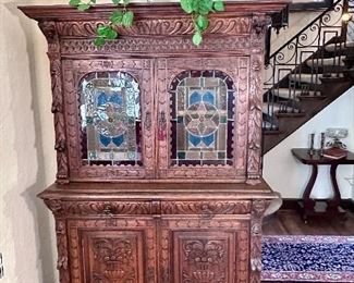 Amazing antique German carved hunt cabinet with leaded glass doors.