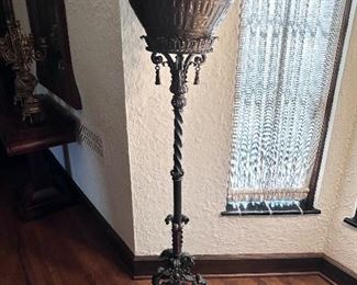 Very ornate metal plant stand shown with English brass pot.