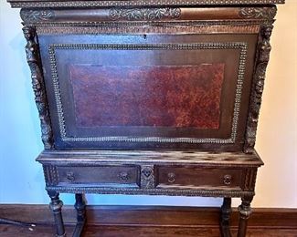 Very beautiful mahogany drop down desk with burled wood interior and carved figures on the sides.