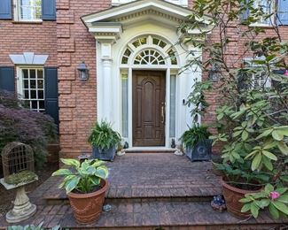 Inviting front entrance, with pair of lead finished cast iron planters, w/wreaths and pice cone finials, pair of large terra cotta pots, w/hosta, marriage of an old birdbath and birdcage thing (it works!) a cast iron horse head finial, pair of glazed terra cotta frogs and a fat, green cast iron frog.