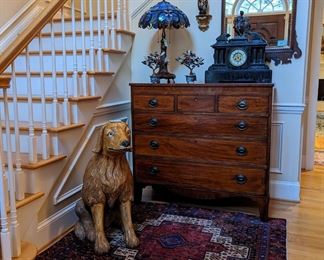 Grand entrance, guarded by the hand-carved ferocity of Butch! Wonderful antique 6-drawer mahogany chest, w/pencil inlay, pair of Asian jade trees in cloisonne pots, statuesque Tiffany-style table lamp, vintage silver plated bowl, w/live orchids, antique black slate and bronze Italian clock, pair of gilt wood sconces and 1970's vintage Henkel-Harris Chippendale "H-6" wall mirror.