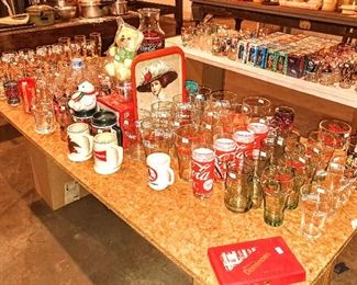 Coca Cola and other collectible glassware and mugs; original vintage Disney glassware new in box on next table, along with Star Wars and Return of the Jedi .