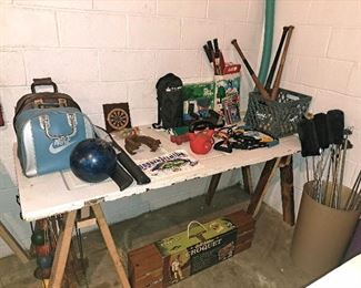 Sport goods, including bowling balls, cue sticks, golf clubs, old baseball pats, two croquet sets, misc exercise equipment and small dart board. 