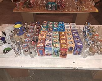 A table full of collectible movie themed glass ware.  Star Wars, Disney, Return of the Jedi.  All barely used and Disney glassware still in original packaging.  All from the 80s and 90's
