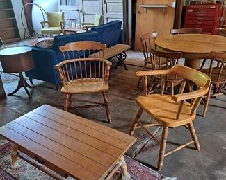 Captains chairs, coffee table and small oriental rug.  In background is great door with opening and shelf in it. 