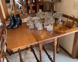 Drop leaf table with collectible glass and Victorian boots