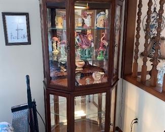Lighted glass display cabinet with head vases and flamingo pieces
