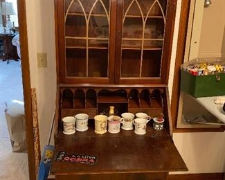 Antique secretary with multiple drawers and drop front desk along with glass fronted display
