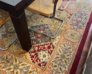 Wool rug, large black wooden table and silver woven chairs