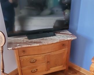 TV on top of a marble top antique table...