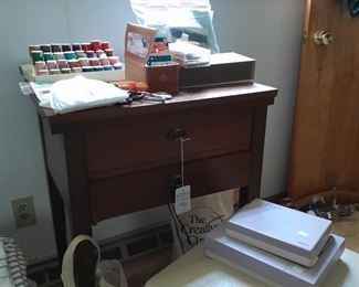 Kenmore sewing machine in cabinet with additional attachments and a sewing chair with storage
