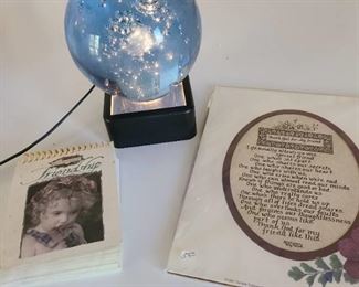 Light base with heavy glass ball with bubbles atop, a friendship calendar and unframed quote