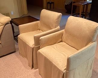 Occasional chairs with a gold tone slipcover.