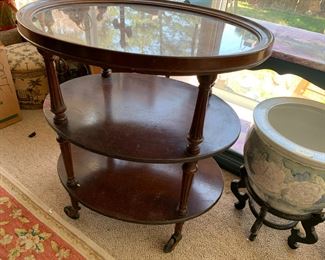 #96	oval 3 shelf table on wheels with glass protect top 26x20x29 as is finish	 $40.00 			
