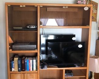 Eighties style oak media center with smoked glass doors.  Two TVs.