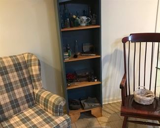 Easy chair and nice rocking chair flanking a bookshelf with vintage bottles and more! Rocker has been moved to living room!