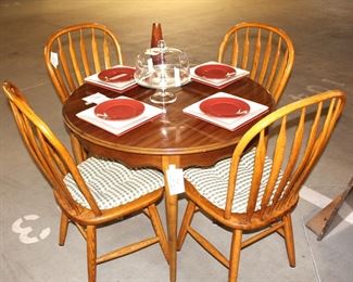 Round table shown with four dining chairs.  