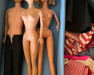 Vintage Barbie dolls with vase and clothing.
