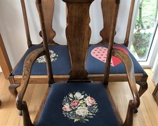 Detail of three of the set of 10 dining chairs. Each seat has unique hand stitched needlepoint design.