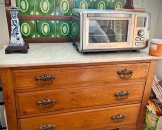 Vintage wood chest with marble top and green tile backsplash