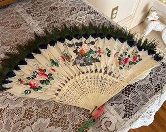 Asian folding fan with peacock feathers 