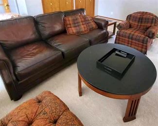 Brown leather sofa from Walter E. Smithe. Round coffee table Stickley furniture. Plaid comfy armchair