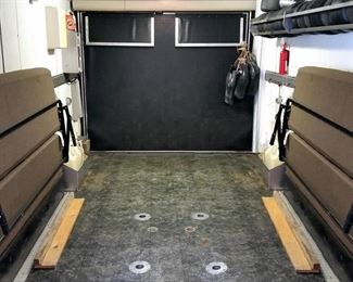 Fold out seating/bed on each side.  Includes table (not shown).   E-track on each side, and D-rings in the floor.