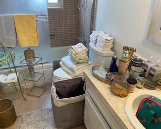 Brass and glass narrow-tiered tables, laundry hampers, towels, vanity mirror and more!