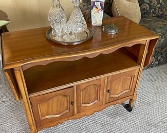 Bar cart on casters with lower cabinet and drop-leaf sides, crystal decanters; rare find vase and coasters