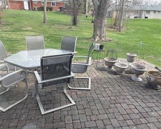 Outdoor patio table with 6 armchairs, large planters and plant stands