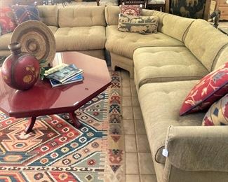 Octagonal red coffee table; tan sectional