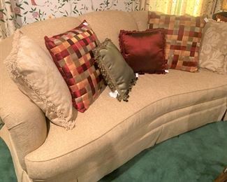 Abundantly inviting curved back sofa; decorative pillows