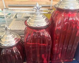 3 red canisters with fleur dis lis finials