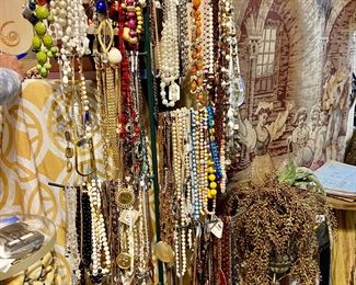 Several racks of necklaces along with six flats of bagged necklaces