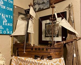 Large wood carved hand crafted ship, lots of other nautical items, fisherman net and we also have a small wooden ship puzzle. There is also a large blue ship wall shelf and an upright ship shelf