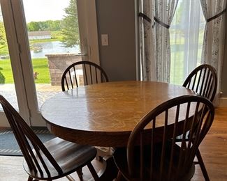 Oak pedestal dining table with 2 leaves and 4 chairs
