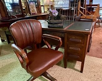 Leather top typewriter desk.  Center section hinges upwards to accommodate and lift a "hidden" typewriter.  Also shown is an antique "Oliver" brand typewriter.