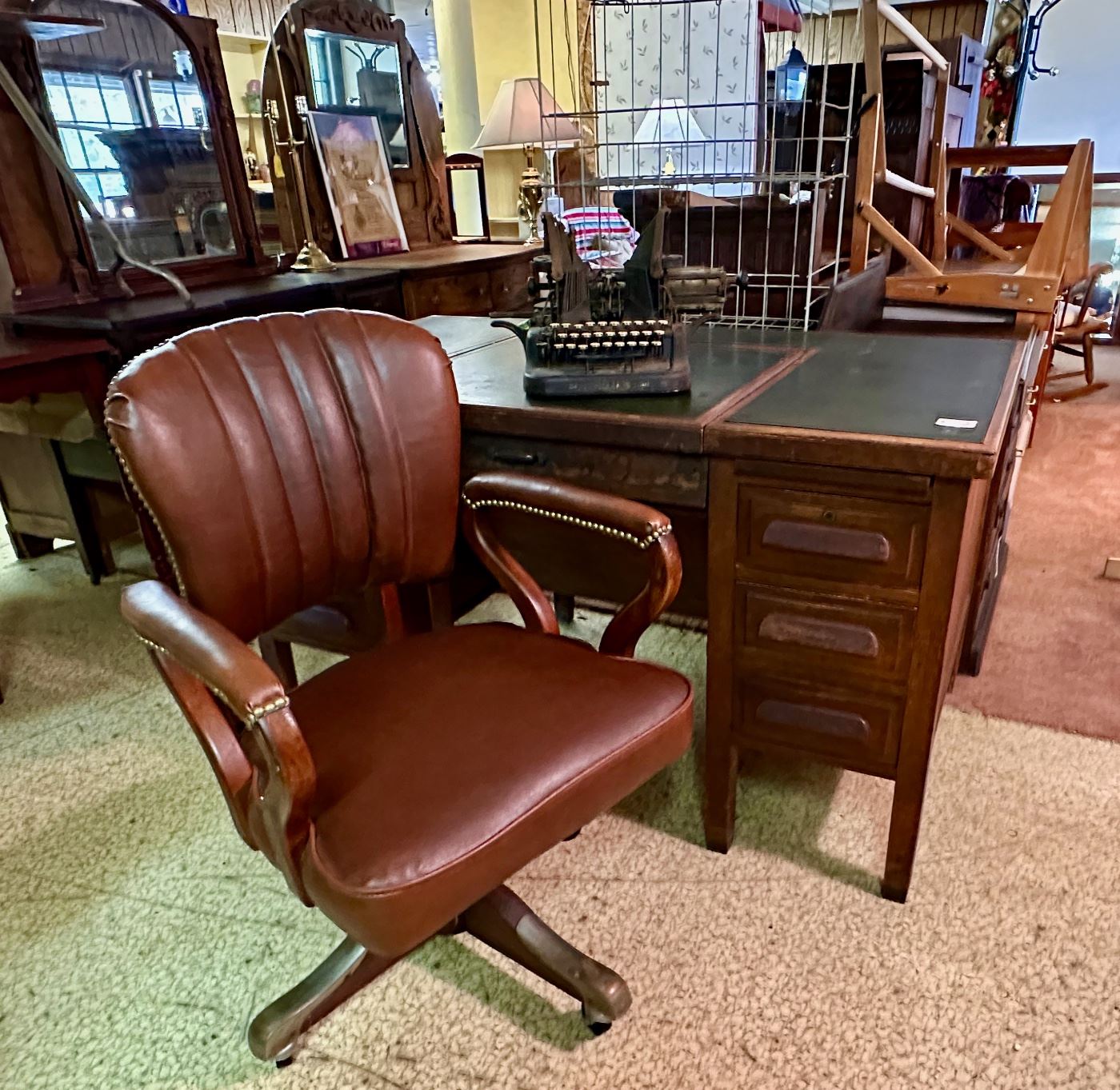 Leather top typewriter desk.  Center section hinges upwards to accommodate and lift a "hidden" typewriter.  Also shown is an antique "Oliver" brand typewriter.