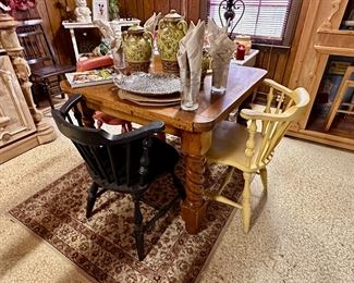 Square dining table with chairs painted in different colors.