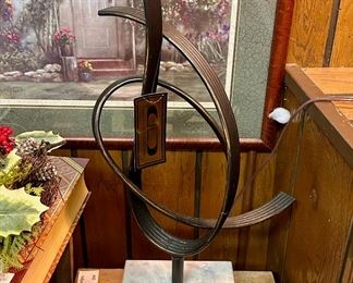 Abstract sculpture on white marble base.