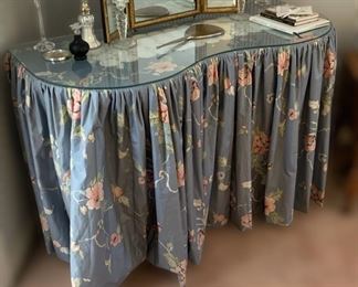 F19 - $35. Kidney Shaped table (plywood frame with slipcover and glass top. Measures 22" deep x 47" wide x 32" tall. 