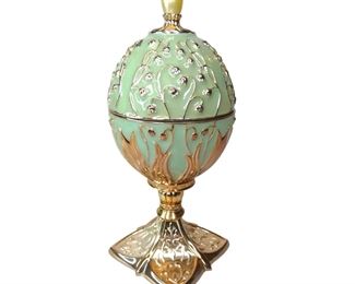 2002 Wallace Silversmiths'- Enameled & Silver-Plated Rotating Musical Easter **Tested & Works Silver plated basket of yellow flowers, two bunnies and a watering can sit on rotating mirror. White silk lined top inside of egg lid. Heavy and Measures approximately 7.5" tall x 3.25" diameter. Base is 2.75" square. In excellent preowned condition with no chips or cracks.