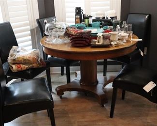 Old oak, pedestal round table; 8 matching black leather side dining chairs