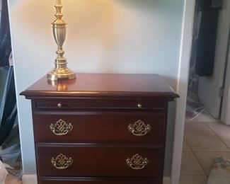 A nice three drawer nightstand with pull out writing table