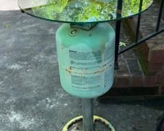 Patio end table made from a propane tank, glass top