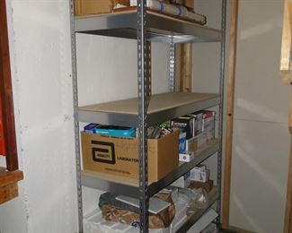 Large assortment of extension cords, lightbulbs and other household items that everyone needs to have on hand, a yes the rack is for sale as well