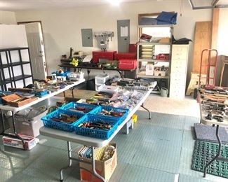 Garage is packed full of tools, paint supplies, tool boxes, and yard tools. 
