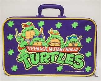 1182 VINTAGE 1989 TEENAGE MUTANT NINJA TURTLES SUITCASE & CONTENTS. SUITCASE APP. 17 IN X 10 1/2 IN X 4 1/4 IN H.
