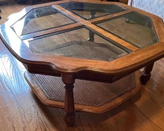 Glass topped coffee table with rattan shelf