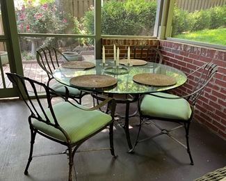 Glass top patio dining table with 4 armchairs; candelabra w/candles; placemats